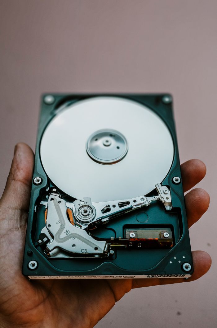 Services Close-up view of an open hard drive held in a hand, illustrating data storage technology.