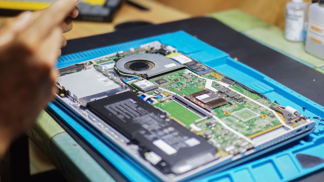 The Art of Drawing Readers In: Your attractive post title goes here Close-up of laptop being repaired with visible components and tools.